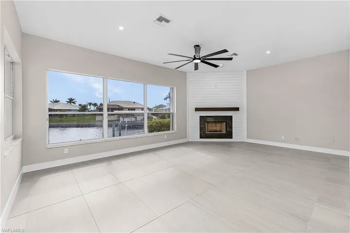 Family room featuring a water view, a shiplap gas fireplace, recessed lighting, and ceiling fan