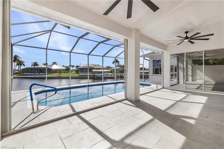 Swimming pool with covered lanai and a water view