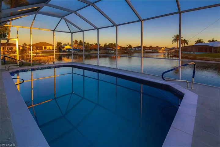 Swimming pool with a lanai, a residential view, and a water view