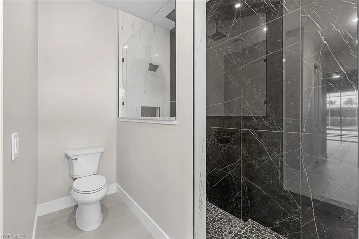 Primary bathroom with light porcelain tile flooring