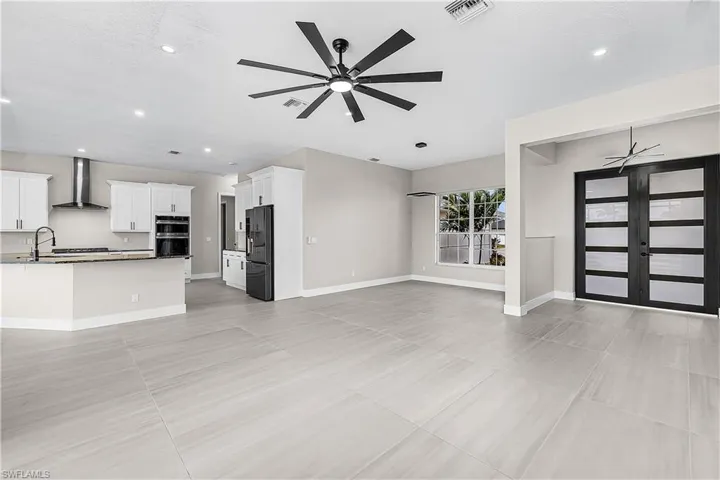 Living and dining rooms featuring a ceiling fan, recessed lighting, and french doors