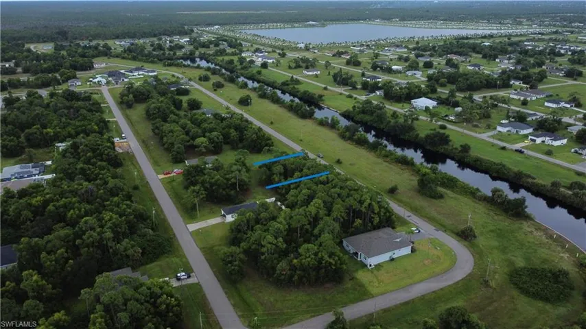 Aerial perspective showcasing a residential area with canal access, established roadways, and scattered homes