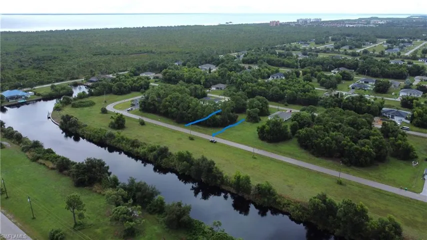 Waterfront property with canal access, established neighborhood, lush green spaces, and coastal proximity