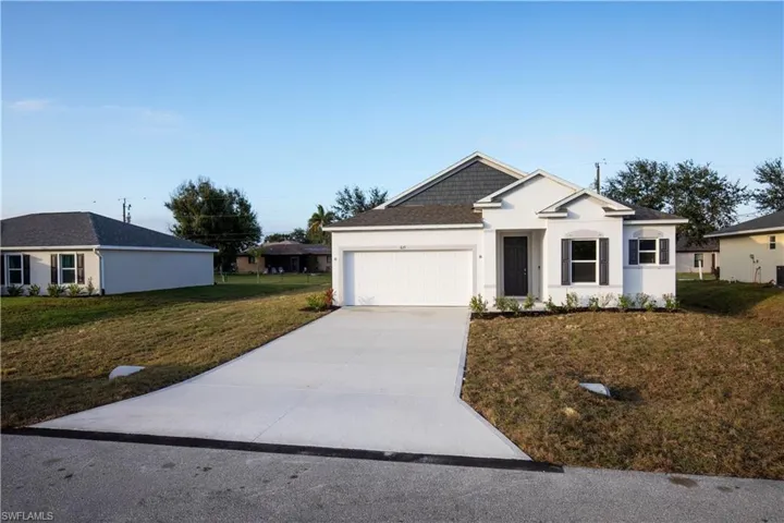 Single story home with a front yard, concrete driveway, stucco siding, and a garage