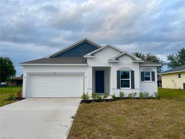 View of front of property featuring a front lawn, stucco siding, driveway, and a shingled roof