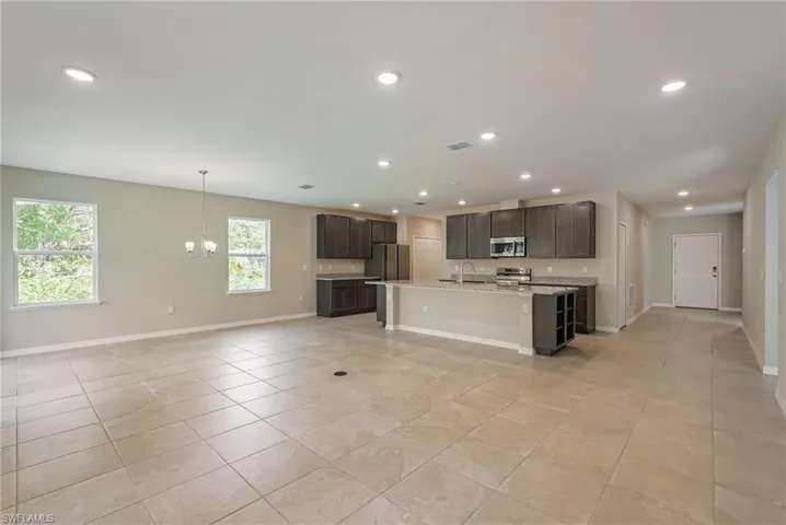 Kitchen with white cabinets, wood tiled floors, open floor plan, and recessed lighting