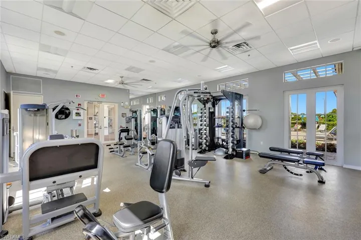 Exercise room featuring a ceiling fan and a paneled ceiling