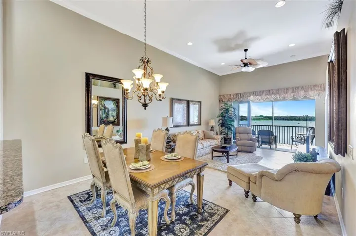 Dining room with crown molding, a water view, light tile patterned floors, recessed lighting, and a chandelier