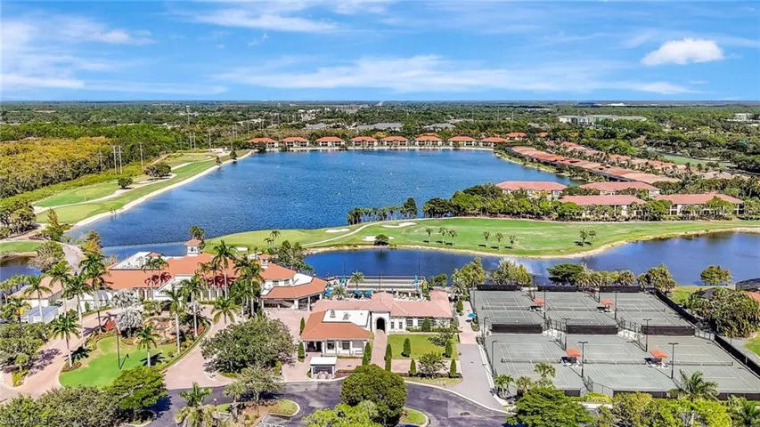 Aerial perspective of suburban area featuring a golf club and a nearby body of water