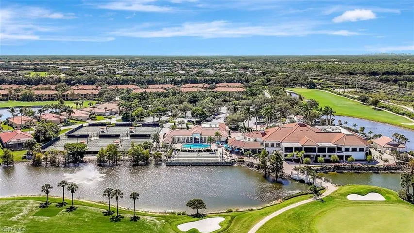 Aerial view of residential area with a golf club and a large body of water