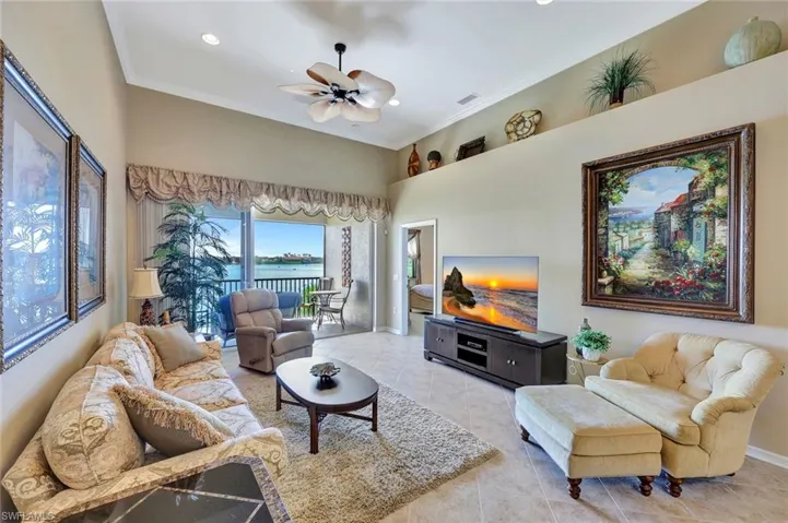 Living area with ornamental molding, a ceiling fan, tile patterned flooring, recessed lighting, and a towering ceiling
