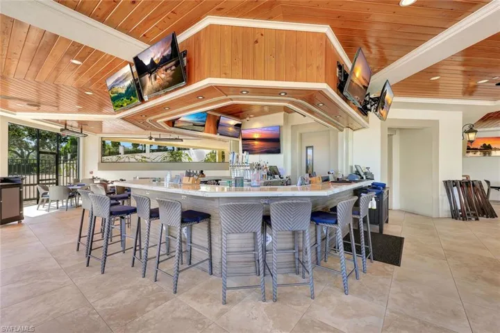 Kitchen with wooden ceiling, ornamental molding, a breakfast bar, plenty of natural light, and recessed lighting