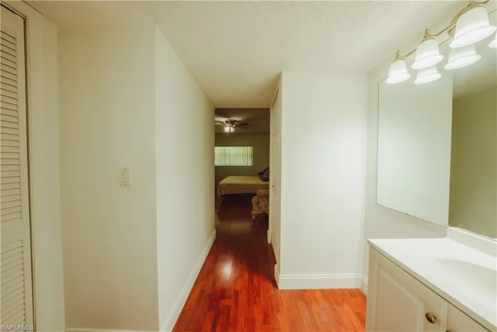 Hall featuring light wood-type flooring and a textured ceiling