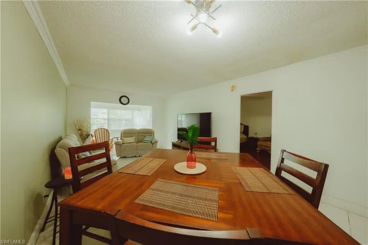 Dining room with a textured ceiling and crown molding