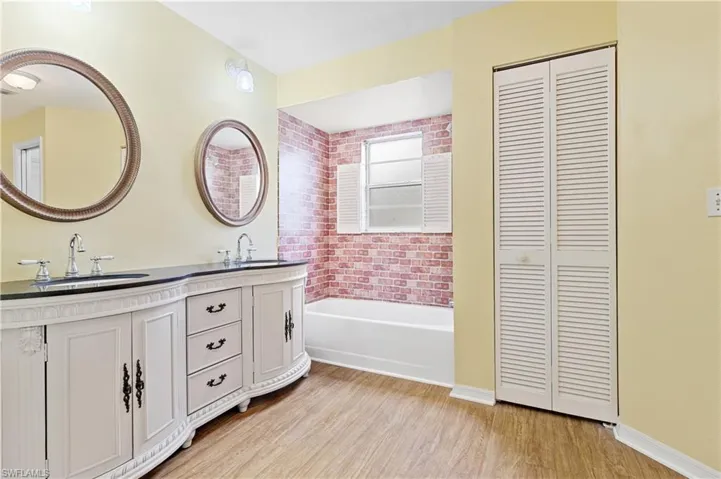 Dual sinks, tub and linen closet.