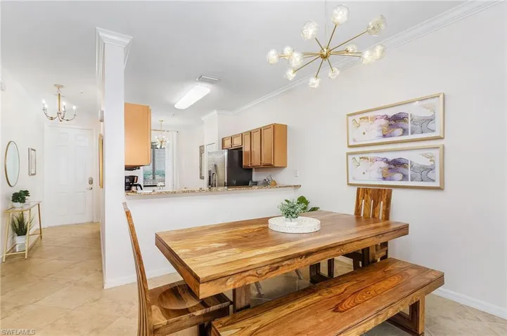 Dining area featuring a chandelier, crown molding, and light tile patterned flooring