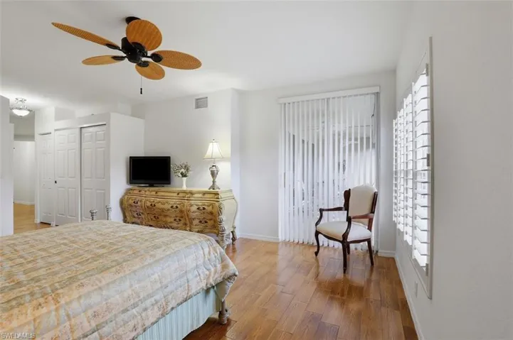 Bedroom featuring wood finished floors, a closet, and a ceiling fan