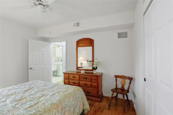 Bedroom with a closet, dark wood-style floors, washer / clothes dryer, and ceiling fan