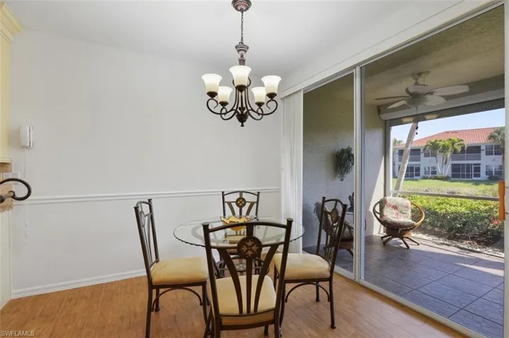 Dining area with a ceiling fan, wood finished floors, and a chandelier