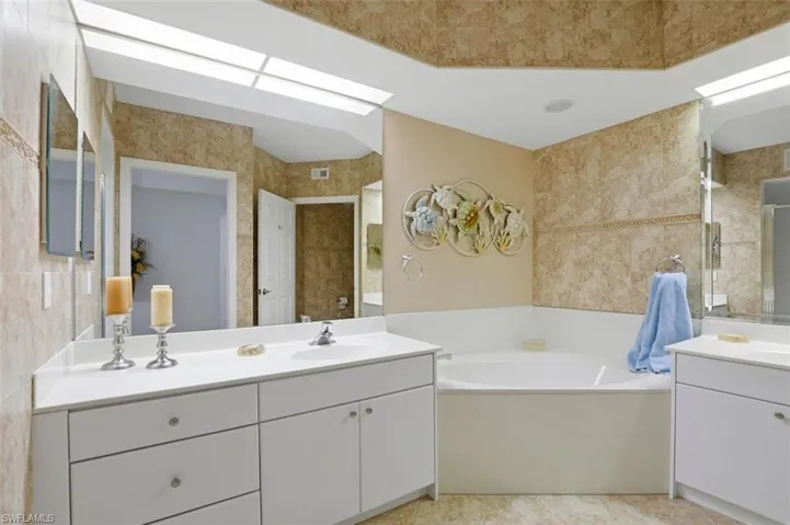 Bathroom featuring a bath and two vanities