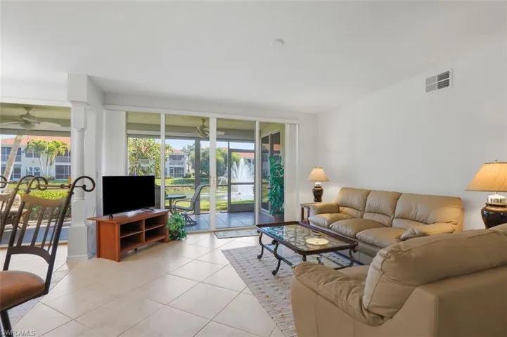 Living room with ceiling fan and tile patterned floors