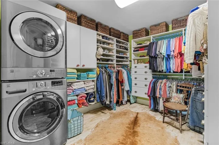 Laundry room featuring cabinets and stacked washer and dryer