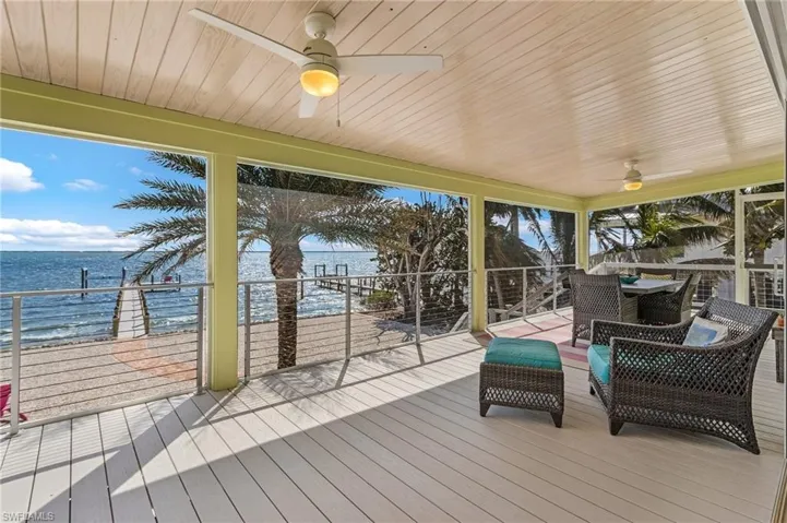 Deck with a water view and ceiling fan