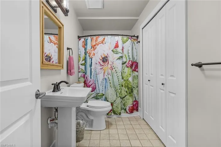 Bathroom with walk in shower, tile patterned floors, toilet, and sink