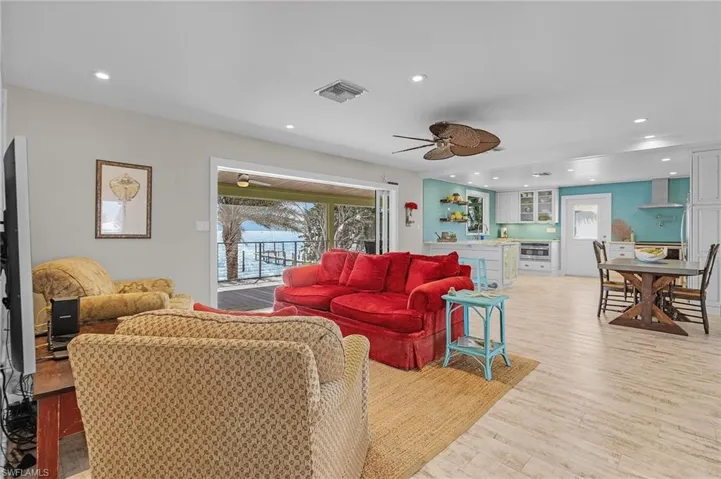 Living room with ceiling fan, plenty of natural light, and light hardwood / wood-style floors