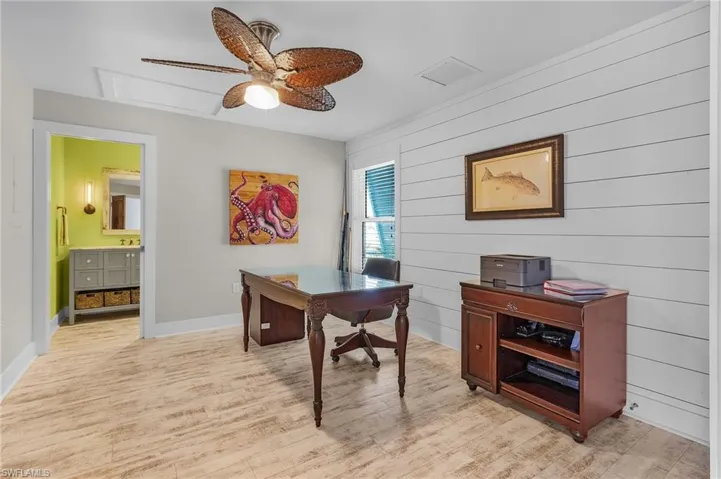 Office with light hardwood / wood-style floors and ceiling fan