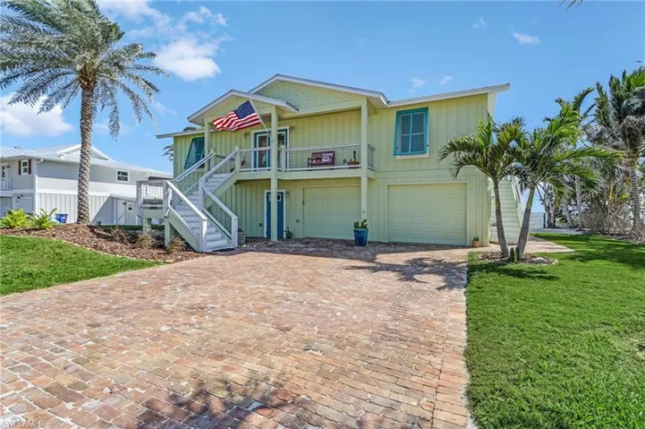 View of front of house featuring a porch, a garage, and a front lawn