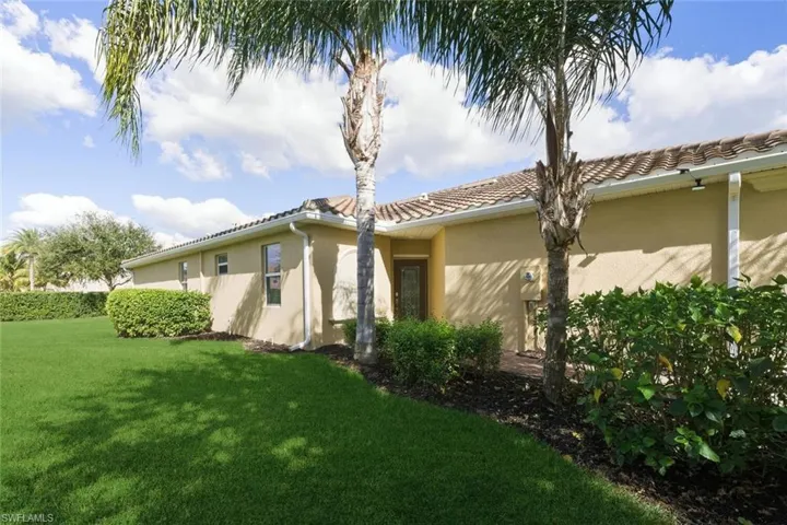 View of home's exterior with stucco siding and a yard