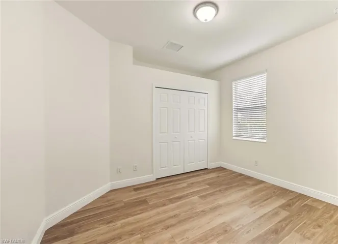 Unfurnished bedroom featuring light wood-style flooring and a closet