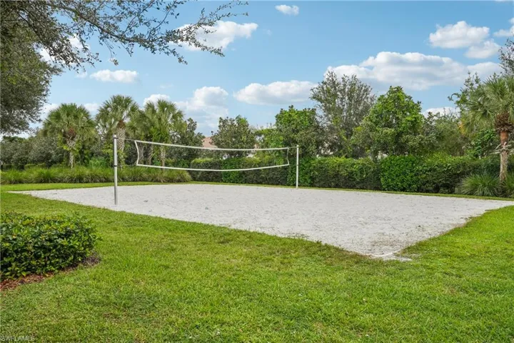 View of property's community with volleyball court and a lawn