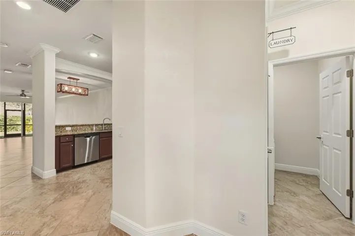 Corridor with ornamental molding, recessed lighting, and light tile patterned floors