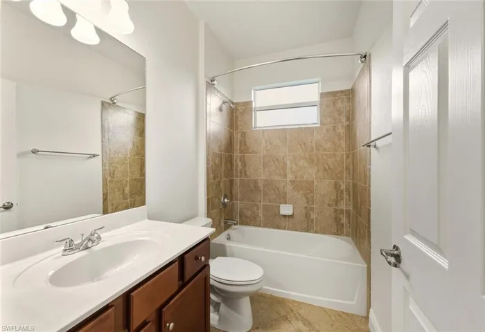 Full bath with  shower combination, vanity, and light tile patterned floors