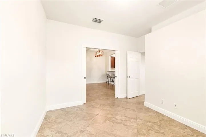 Spare bedroom featuring baseboards and a chandelier
