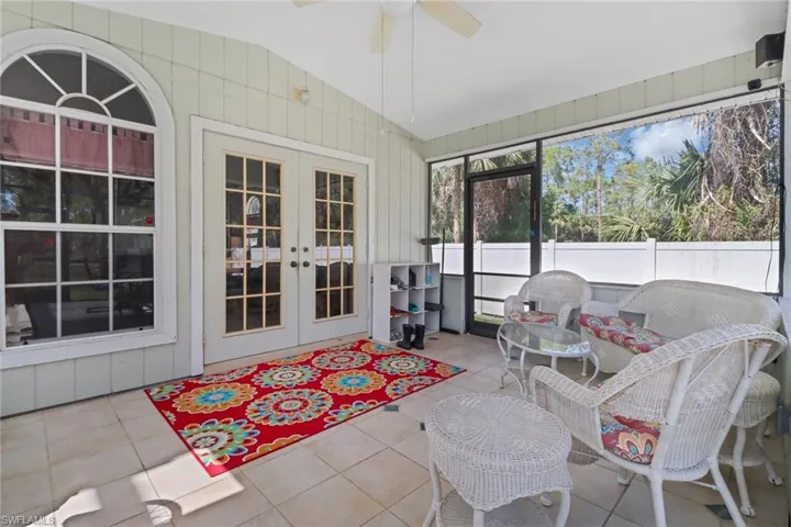 Sunroom / solarium featuring vaulted ceiling, a ceiling fan, and french doors