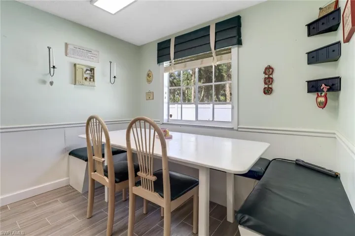 Dining space with wood tiled floor and a wainscoted wall
