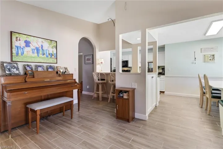 Living area featuring wood finish floors, arched walkways, and baseboards