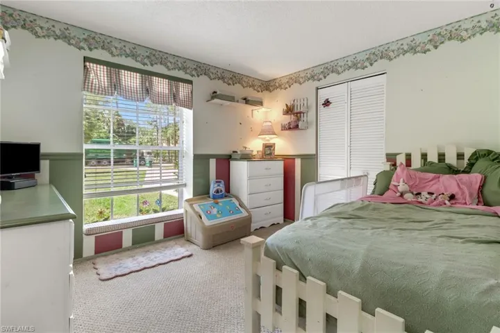 Carpeted bedroom featuring a closet and a textured ceiling
