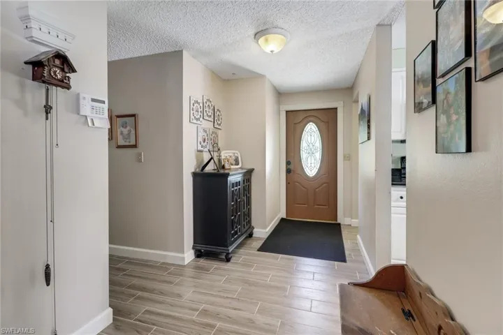 Entryway with wood tiled floor, baseboards, and a textured ceiling