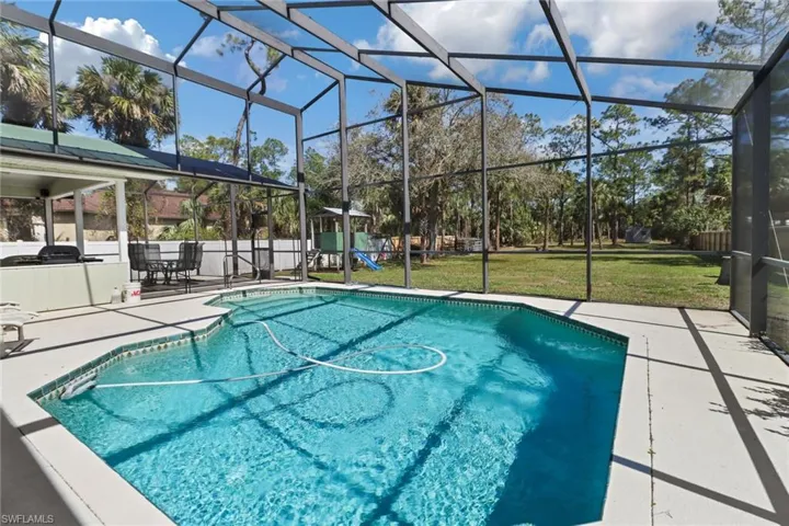 View of swimming pool with a lanai, a patio area, a fenced in pool, and a yard