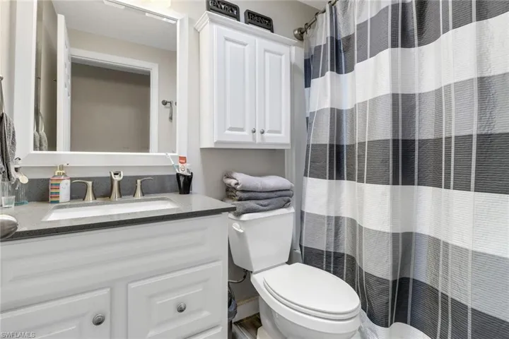 Full bath with a shower with curtain, vanity, and toilet