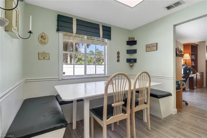 Dining space with visible vents, breakfast area, and wood finish floors