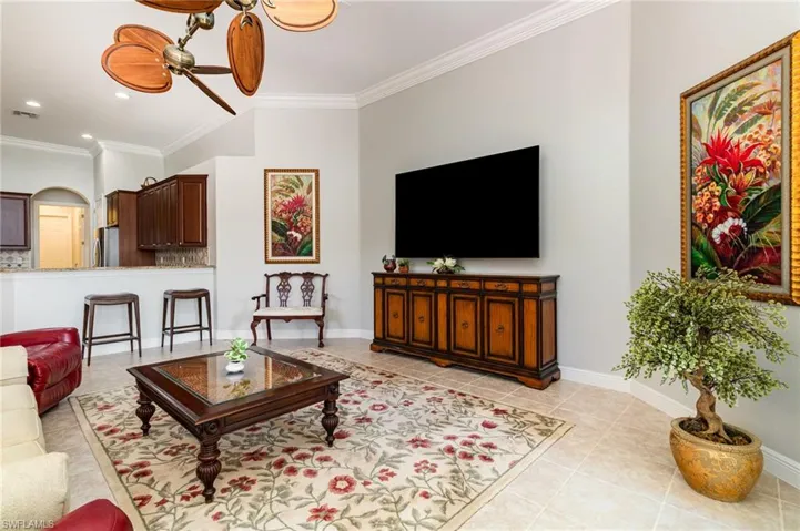 Living room featuring crown molding, a ceiling fan, light tile patterned flooring, and recessed lighting