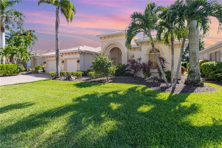 Mediterranean / spanish-style home with an attached garage, stucco siding, a tiled roof, and a front lawn