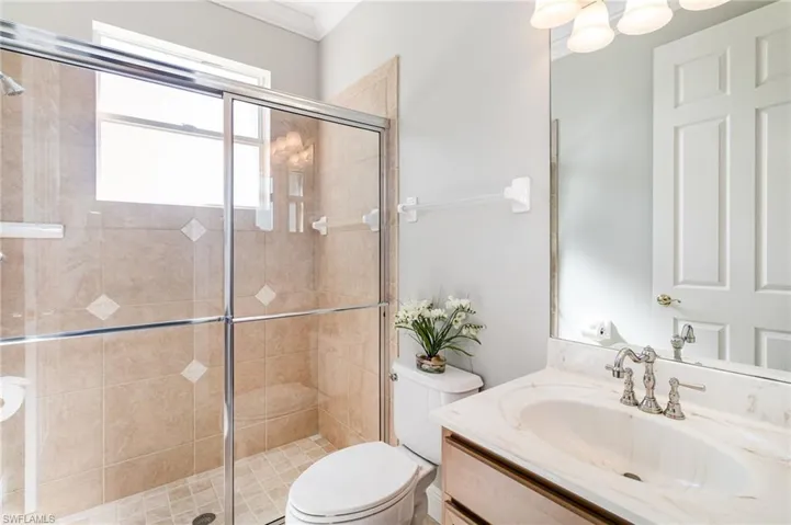 Full bath with vanity, a stall shower, and crown molding