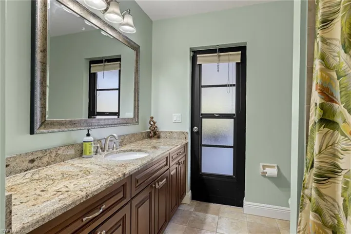 Bathroom with tile patterned flooring, vanity, and a healthy amount of sunlight