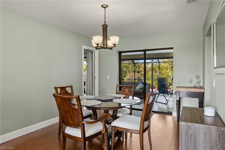 Dining area featuring a notable chandelier and dark wood-type flooring